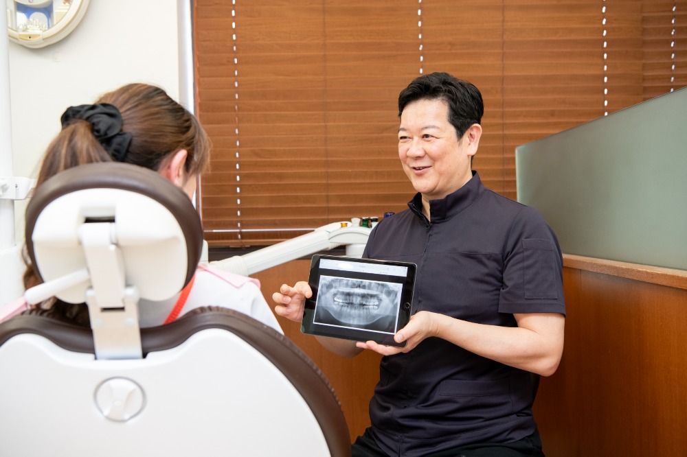 歯列模型を持つ白衣を着た男性